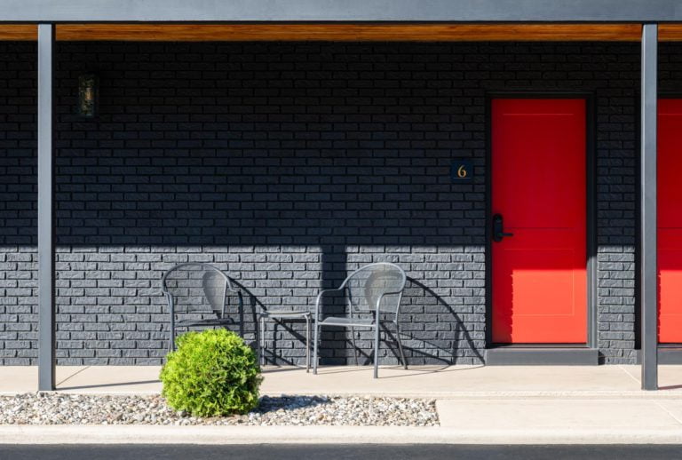 A black building with a red door.