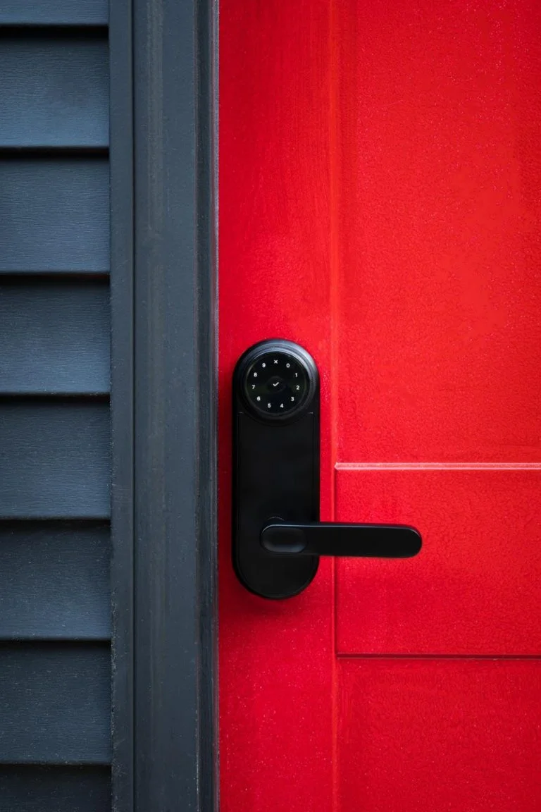 A black door handle on a red door.