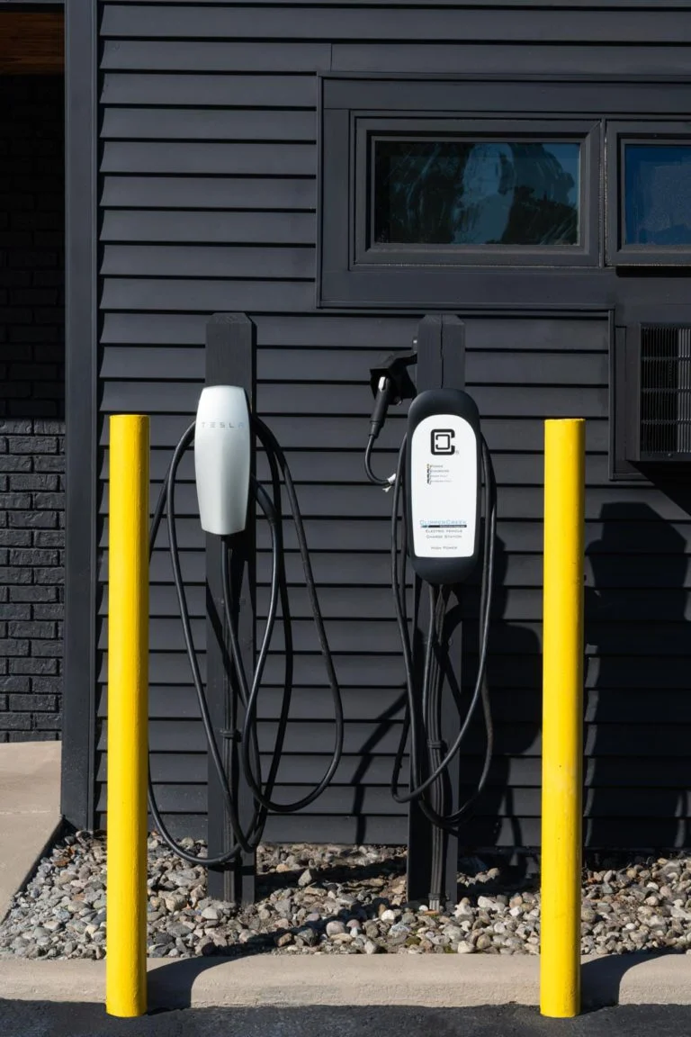 Two electric car charging stations in front of a building.