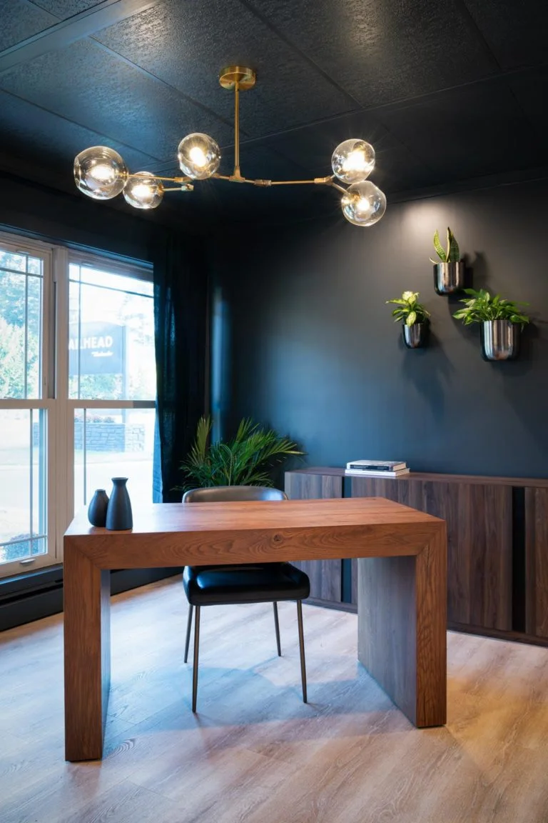 An office with black walls and a wooden desk.