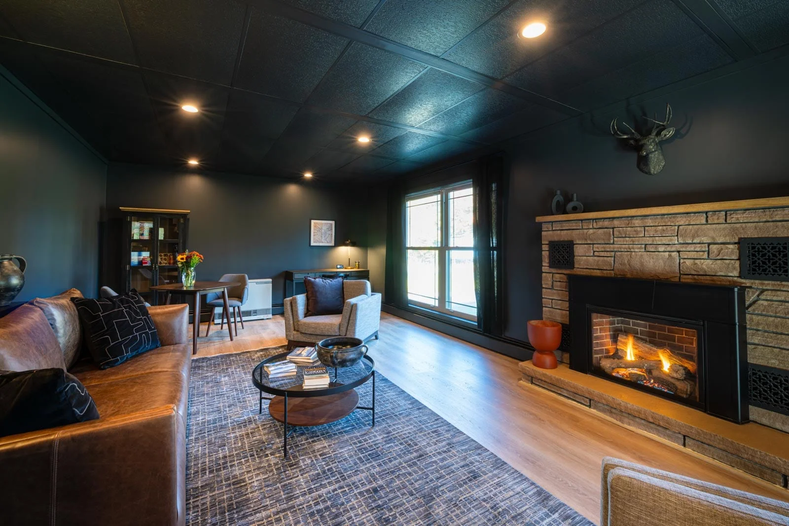 A living room with black walls and a fireplace.