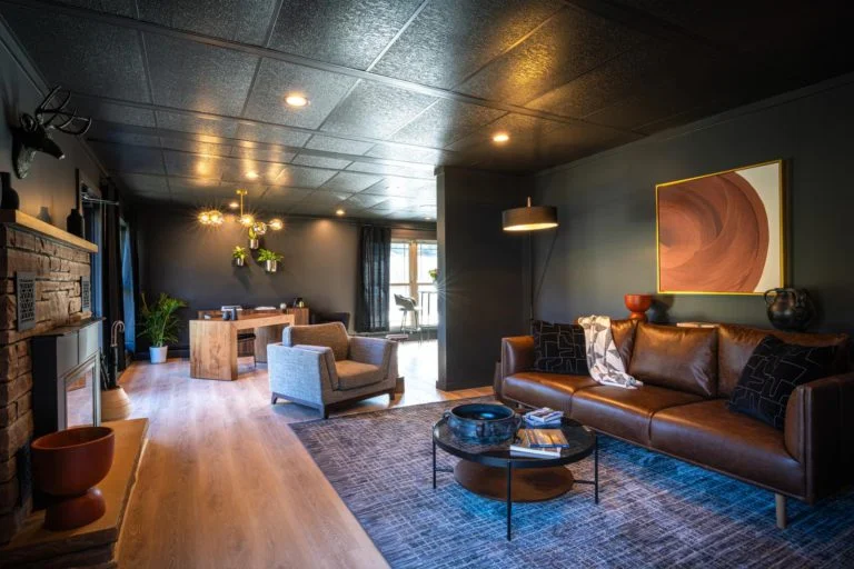 A living room with black ceilings and leather furniture.