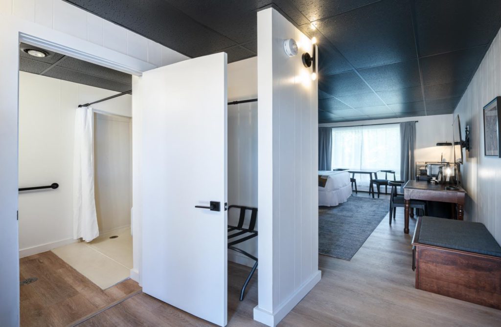 A room with a door leading to a bathroom.