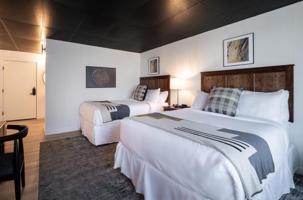 Two beds in a room with a black ceiling.