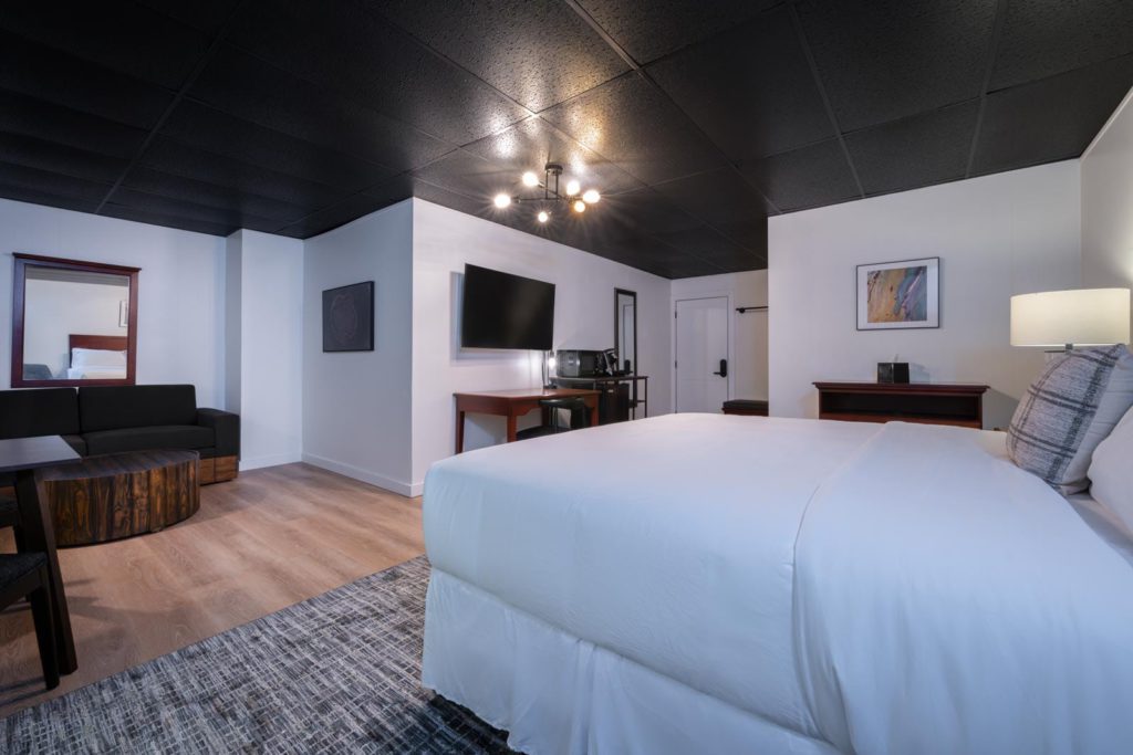 A hotel room with a bed and a tv.