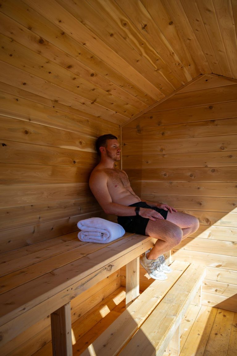 A man sitting on a bench in a sauna.